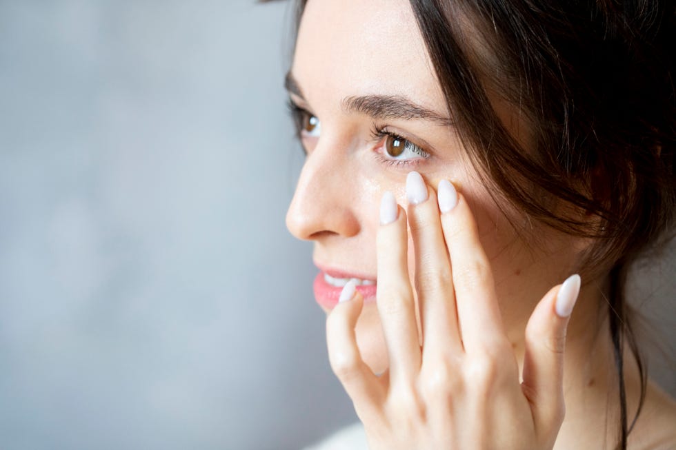 mujer aplicandose contorno de ojos