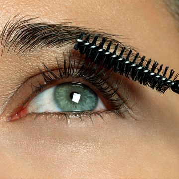 woman applying eyelash makeup, close up