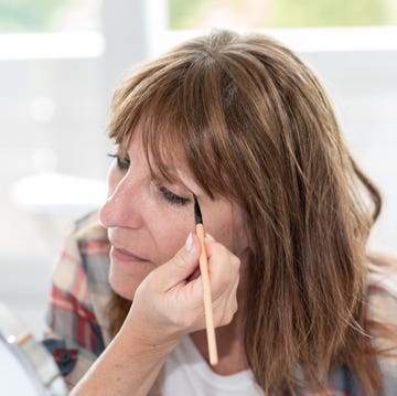 Woman applying eyeshadow powder Woman applying eyeshadow powder