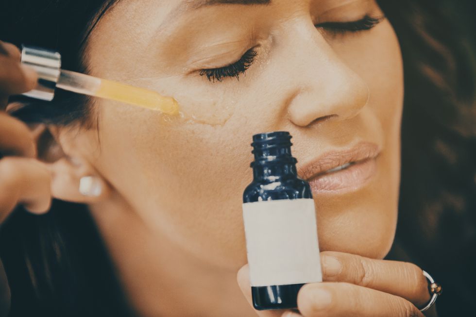 woman applying face serum