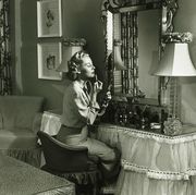 woman applying lipstick at vanity table