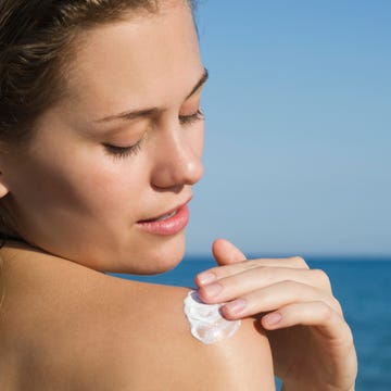 Woman applying sunscreen at the beach woman applying sunscreen at the beach