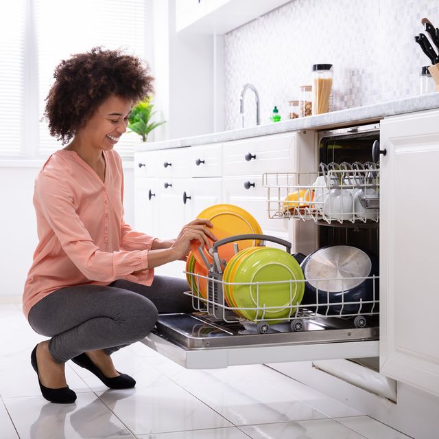 a woman loading a dishwasher in the kitchen