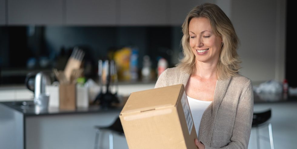 Woman at home getting a parcel in the mail