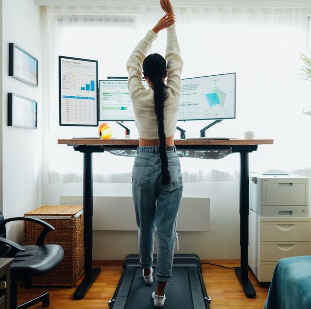 woman at home office is walking on under desk treadmill