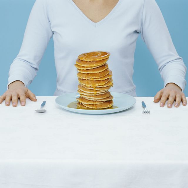 woman at table with plate of pancakes, mid section digital composite