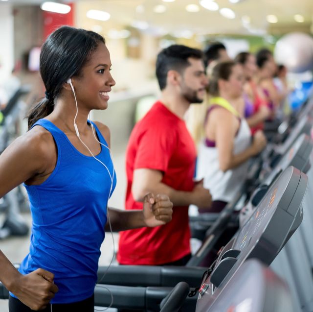 woman at the gym running on the treadmill and listening to music