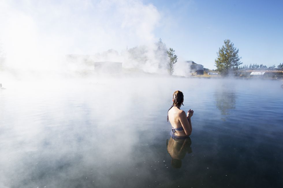 a woman bathing in the secret lagoon in iceland