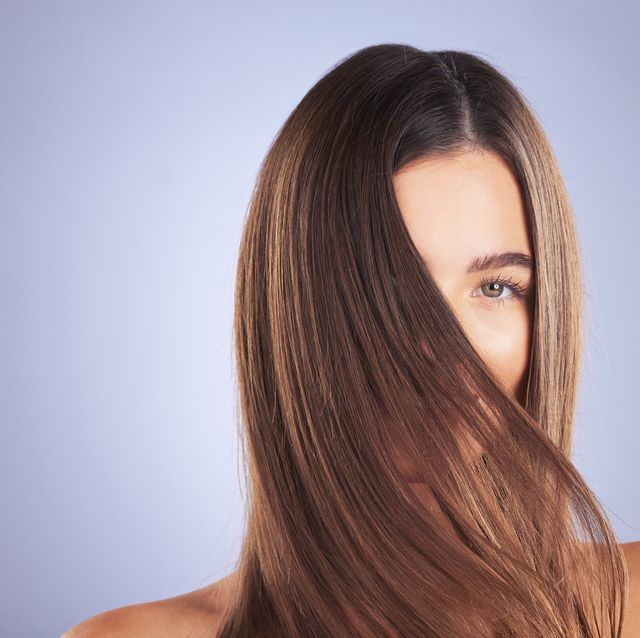 woman, beauty and hair portrait in studio for space, growth and healthy shine on blue background aesthetic female model for haircare texture, self care and cosmetic results for salon or hairdresser
