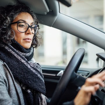 woman behind the wheel using phone for navigation