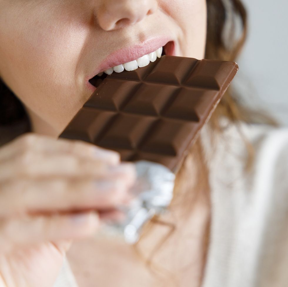 woman biting a chocolate bar
