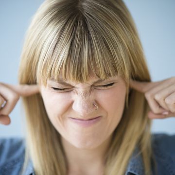 Woman blocking ears with fingers