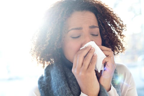 Woman blowing nose on tissue