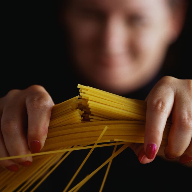 Woman Breaking Spaghetti