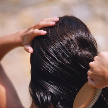 Woman brushing wet hair, close-up, rear view woman brushing wet hair, close up, rear view