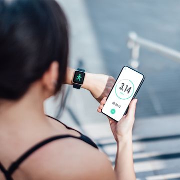 woman checking her smart watch and mobile phone after run