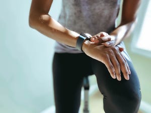 woman checks her fitness stats on smart watch after indoor cycling workout