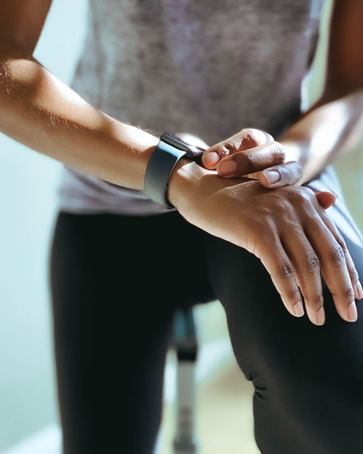 woman checks her fitness stats on smart watch after indoor cycling workout