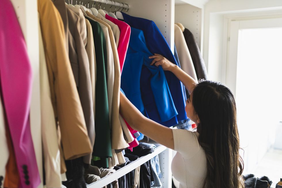 woman choosing clothes in closet