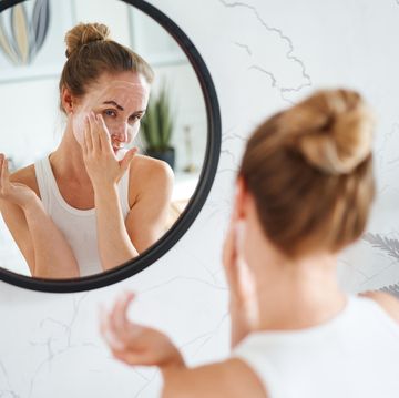 woman cleaning face with cosmetic product