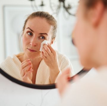 woman cleaning face in bathroom
