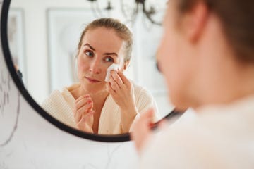 woman cleaning face in bathroom