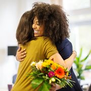 woman congratulating female coworker over her success