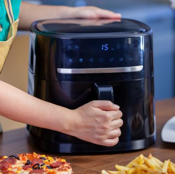 woman cooking food with air fryer in the kitchen.