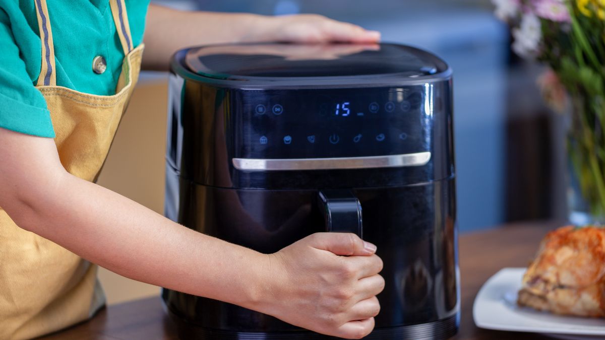woman cooking food with air fryer in the kitchen.