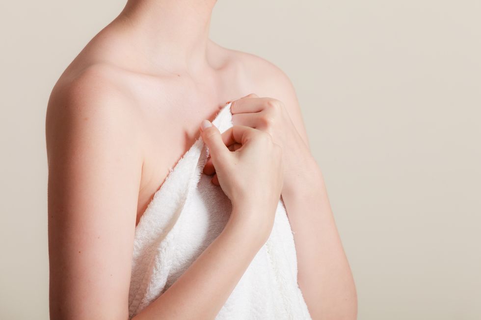 woman covering breast under towel