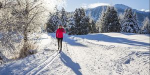 Woman cross country skiing on sunny day.
