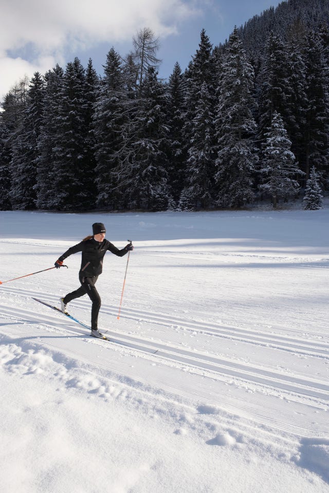 woman cross country skiing, sunset wide angle