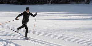 woman cross country skiing, sunset wide angle