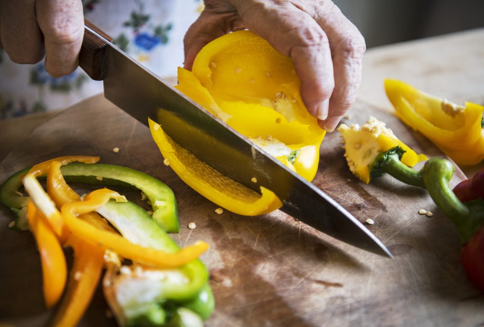 woman cutting bell pepper on a cutting board