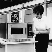 when was the microwave invented, woman demonstrates microwave oven