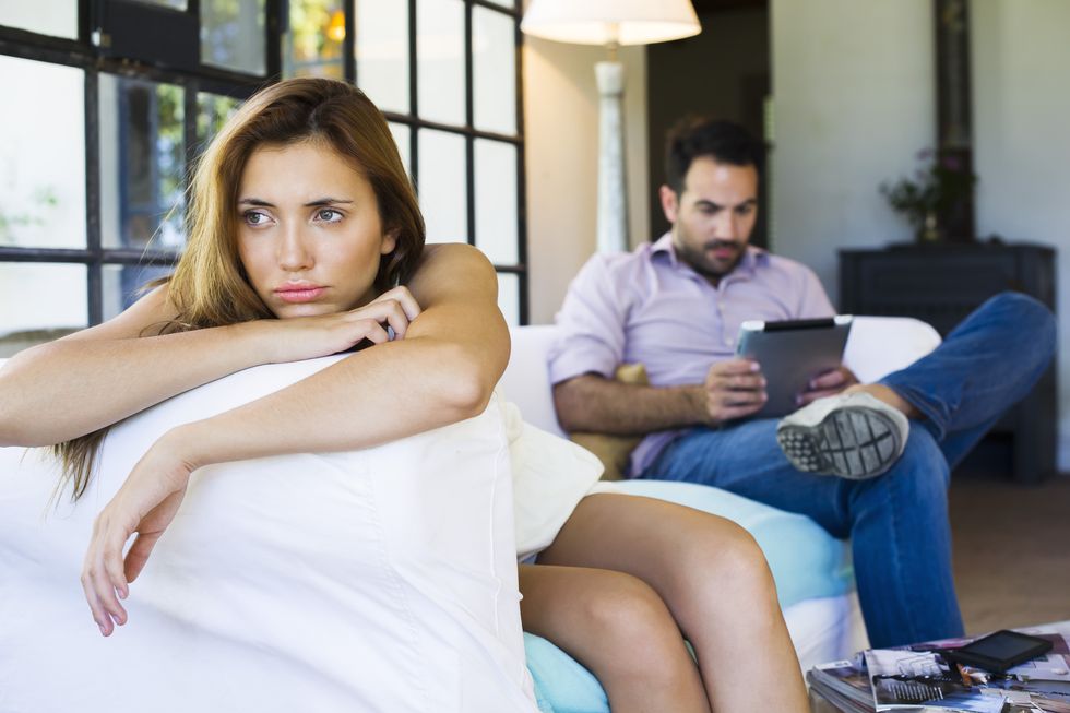 woman displeased by boyfriend on digital tablet