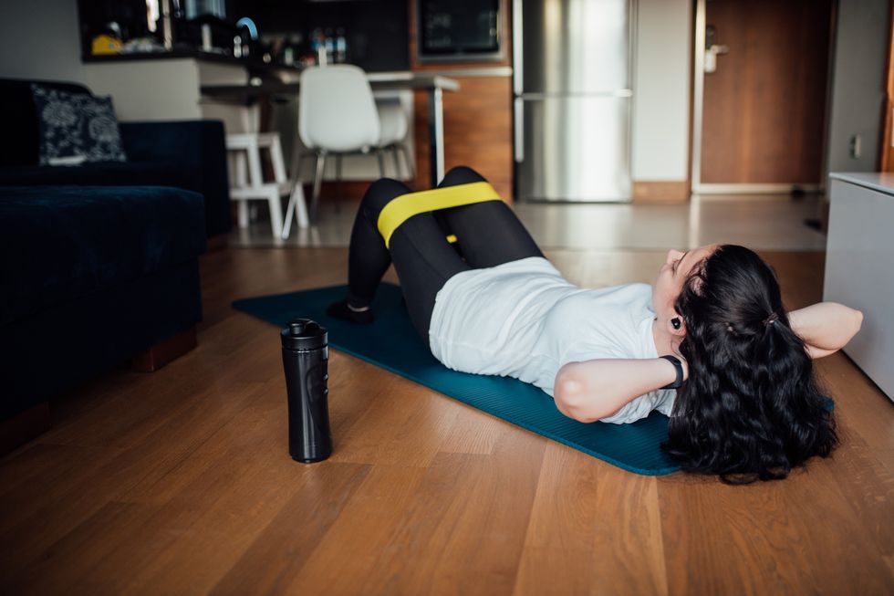 woman doing exercises with resistance band at home