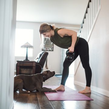 woman doing home fitness exercises with her dog