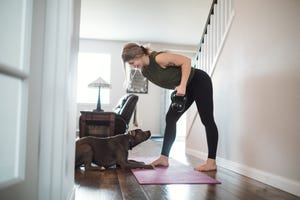 woman doing home fitness exercises with her dog