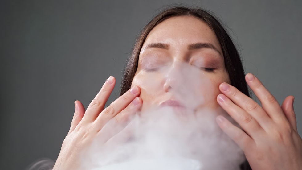 woman doing steam therapy with humidifier sitting in room
