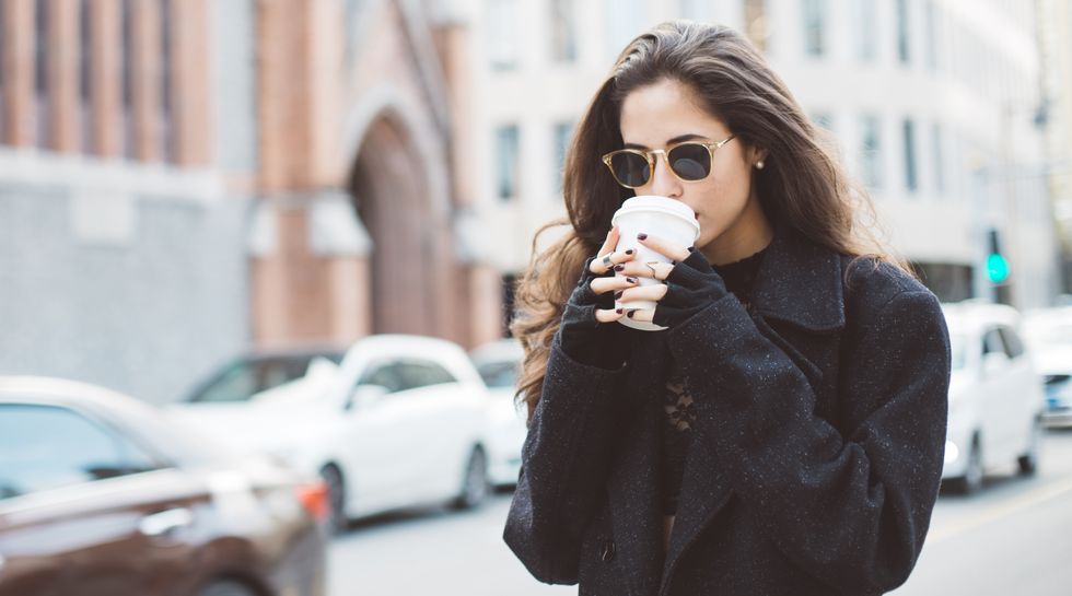 woman drinking coffee in the city