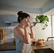 Woman drinking from mug in zero waste kitchen. woman drinking from mug in zero waste kitchen