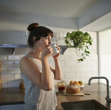 woman drinking from mug in zero waste kitchen.