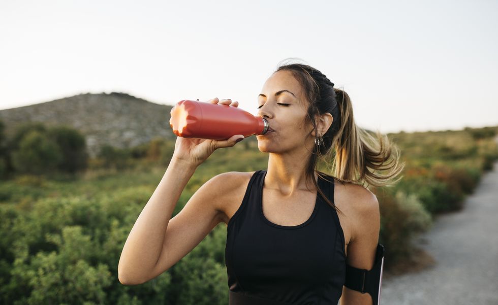 woman drinking water after workout