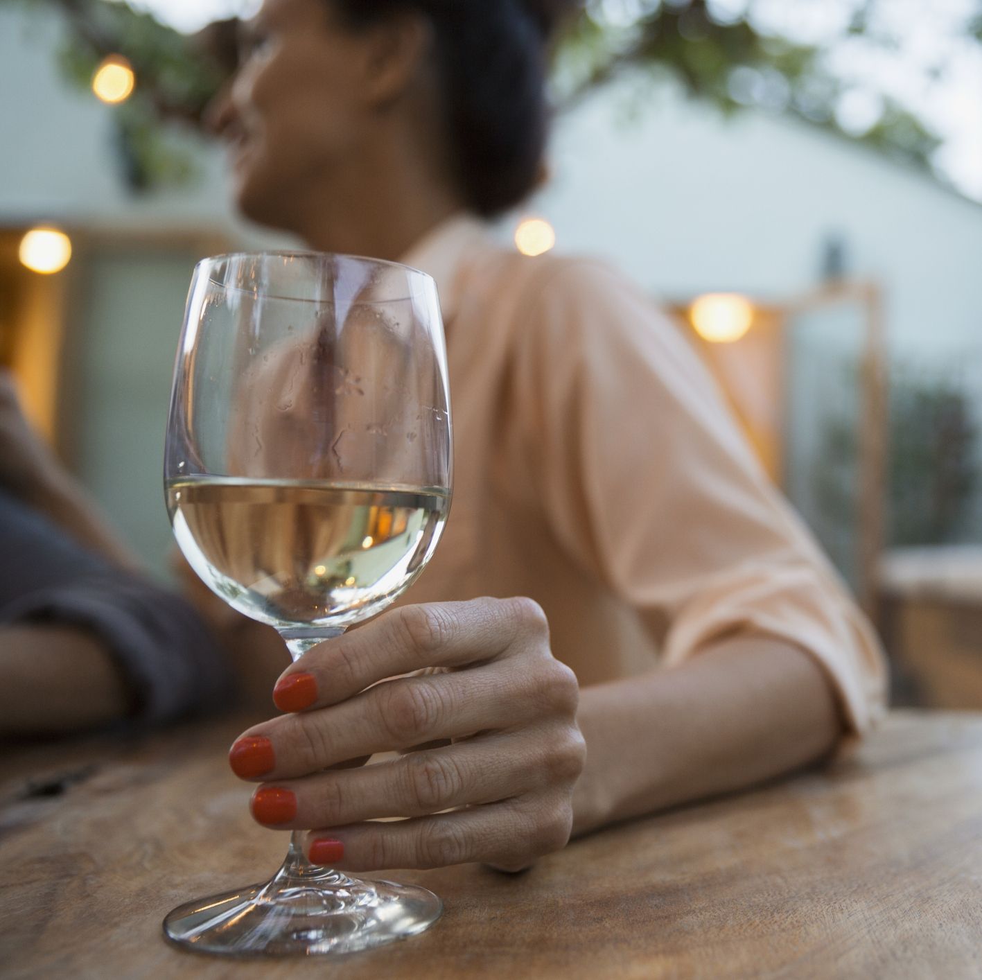 Woman drinking white wine on patio