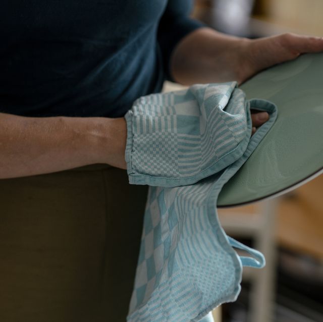 woman drying plate with dish towel, close up