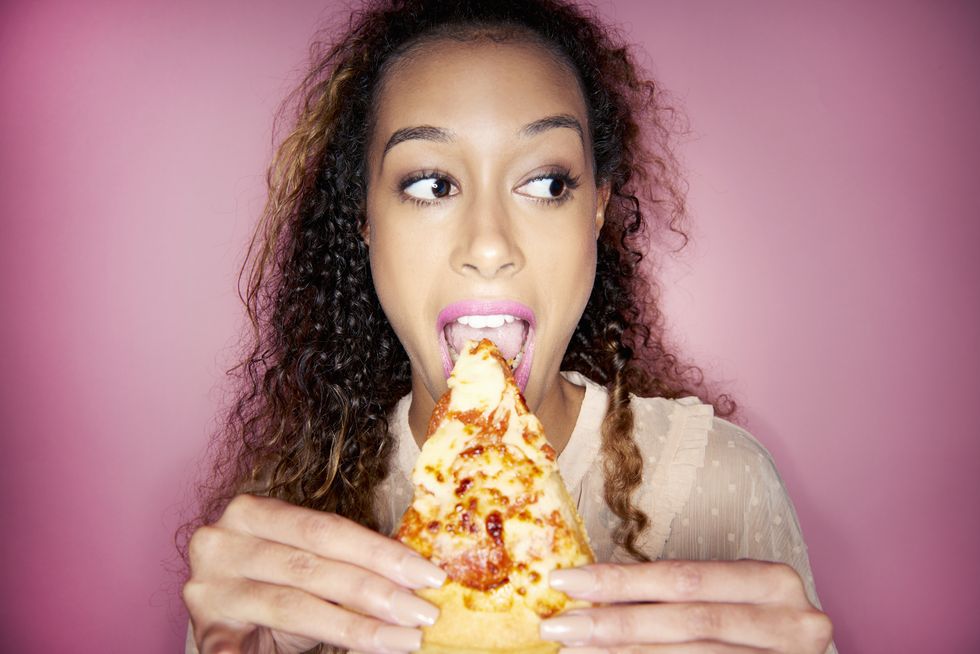 woman eating pizza slice