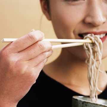 a woman eating soba, close up, side view