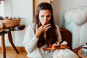 woman eating sweet food while sitting at home