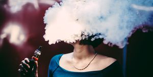 Woman Emitting Smoke While Smoking At Home